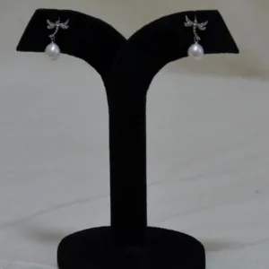 Pair of silver dragonfly drop earrings on black display stand
