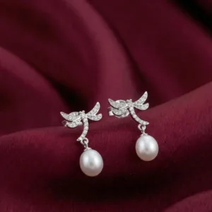 Pair of dragonfly 925 silver earrings with pearl-look drops on burgundy fabric