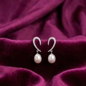 Pair of pearl-look curve 925 silver drop earrings on burgundy fabric