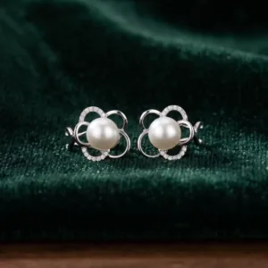 Pair of pearl-look floral 925 silver stud earrings on green velvet