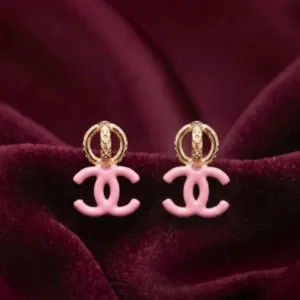 Pair of pink double-C gold plated drop earrings on burgundy fabric